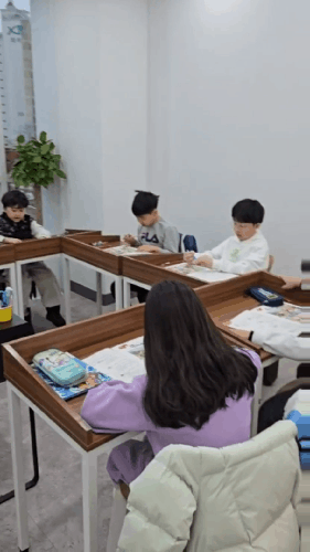 책상에서 글을 쓰는 아이들